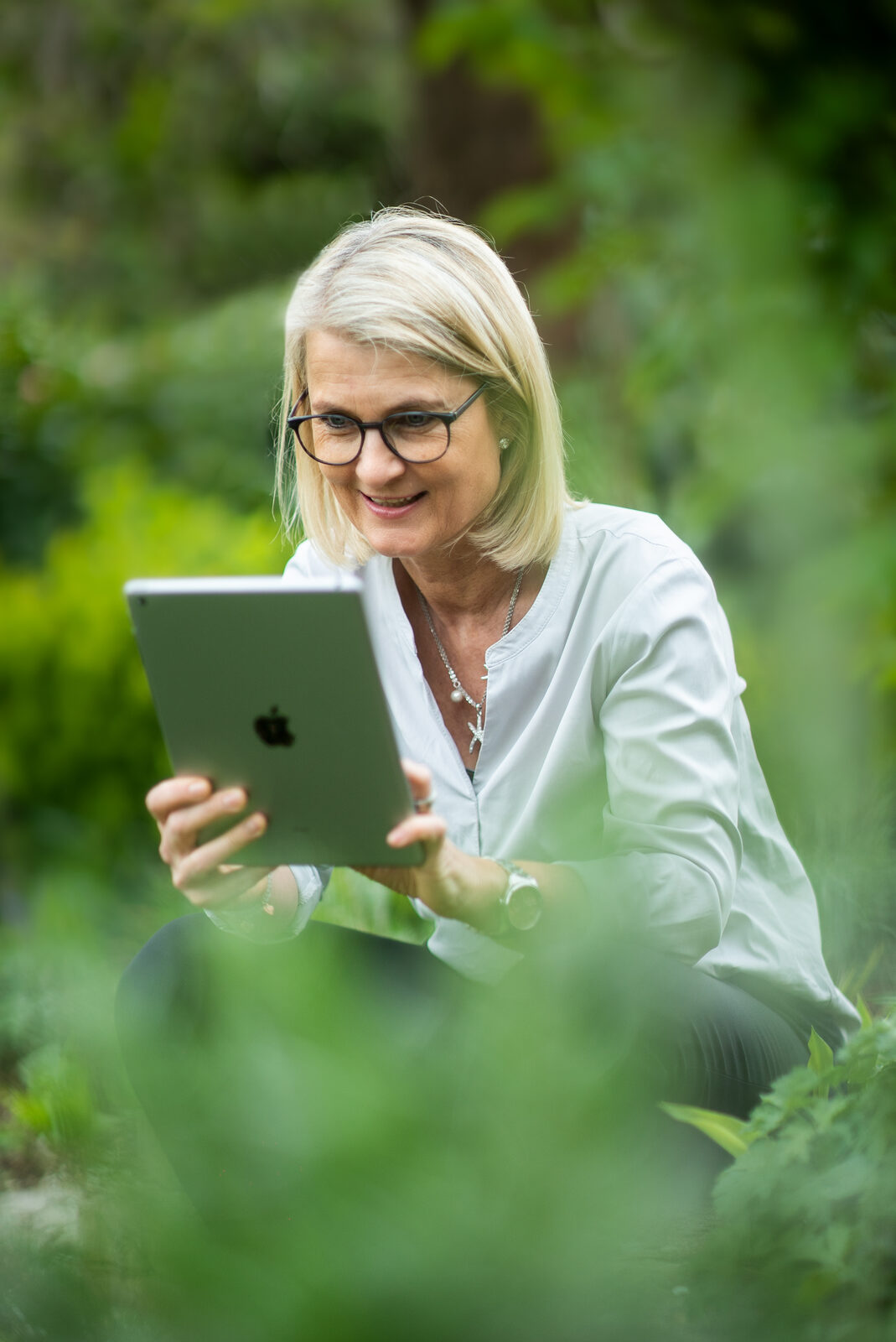 Angela Rakowitz, Business Coach für Führungskräfte, mit Tablet im Garten